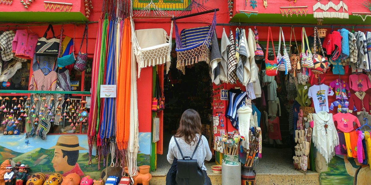 A solo traveller browsing a colourful market stall in Colombia